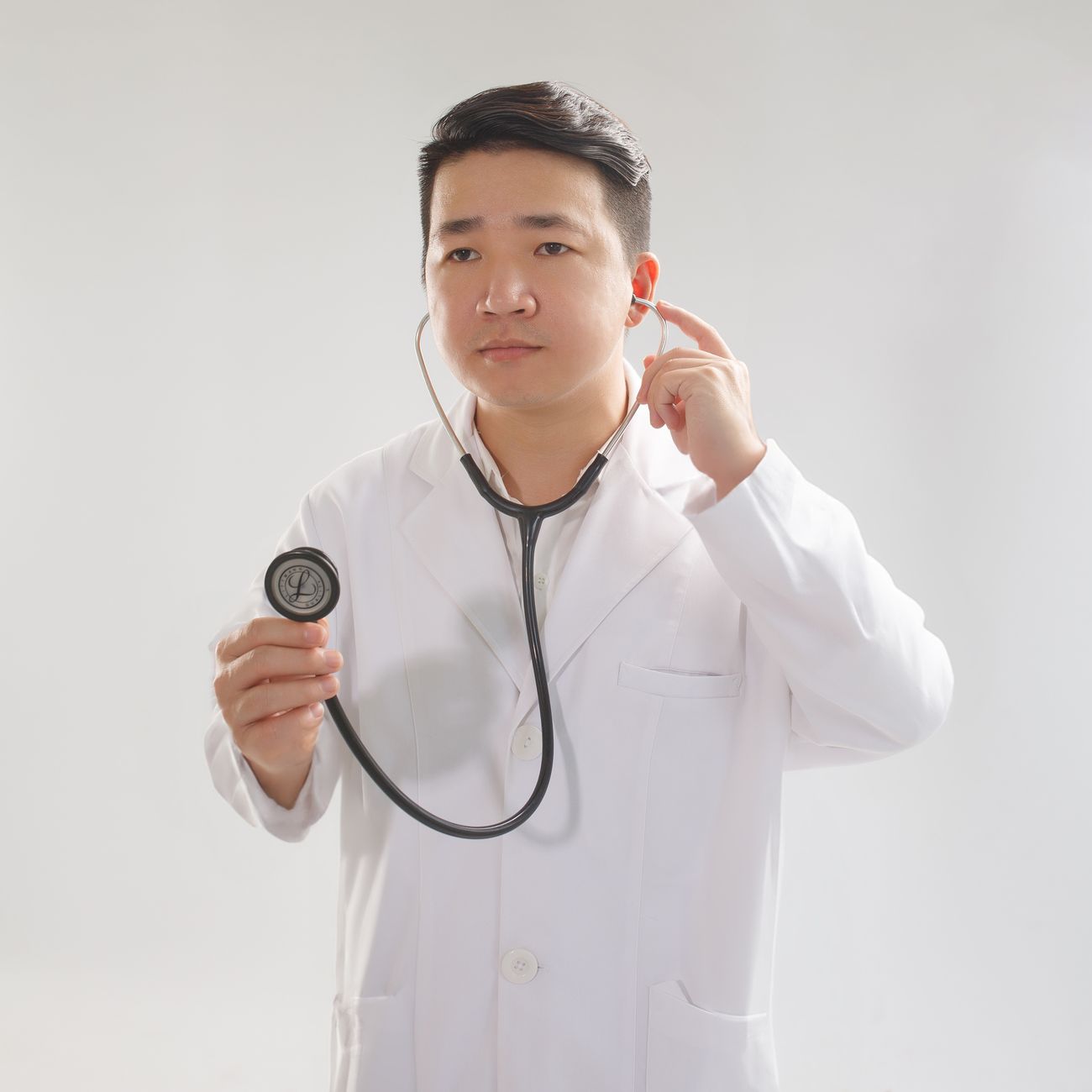 portrait of aesthetician in clean white clinical coat with natural daylight behind